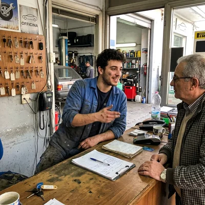 Kevin A. Pinto, shop manager at Pinto's Auto Repair, talking with a customer at the service desk