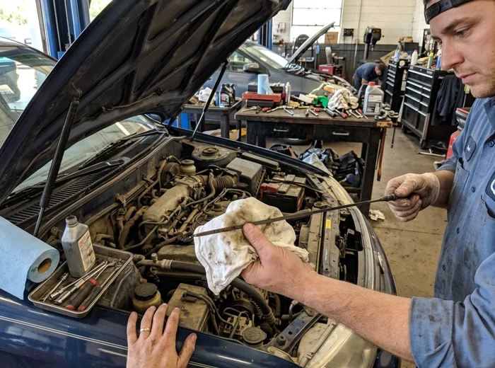 Dipstick showing dark used engine oil before a scheduled oil change